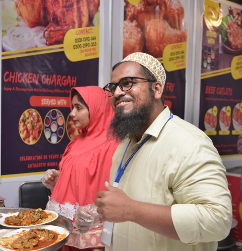 A Bohra couple selling food in a Bohra festival