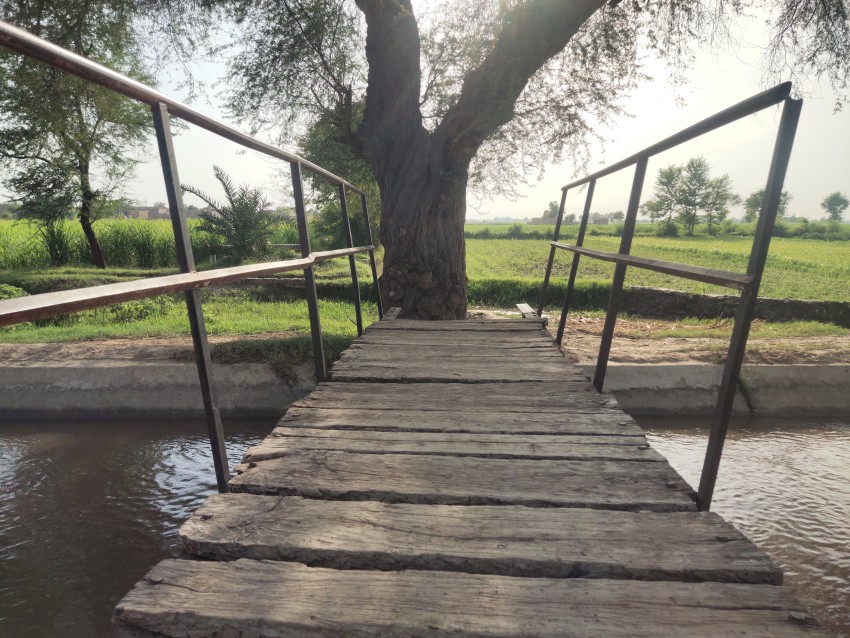 A bridge made of iron and wood over a flowing canal