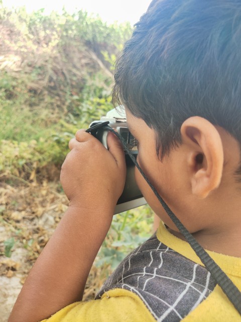 A child focusing the camera while taking a photo