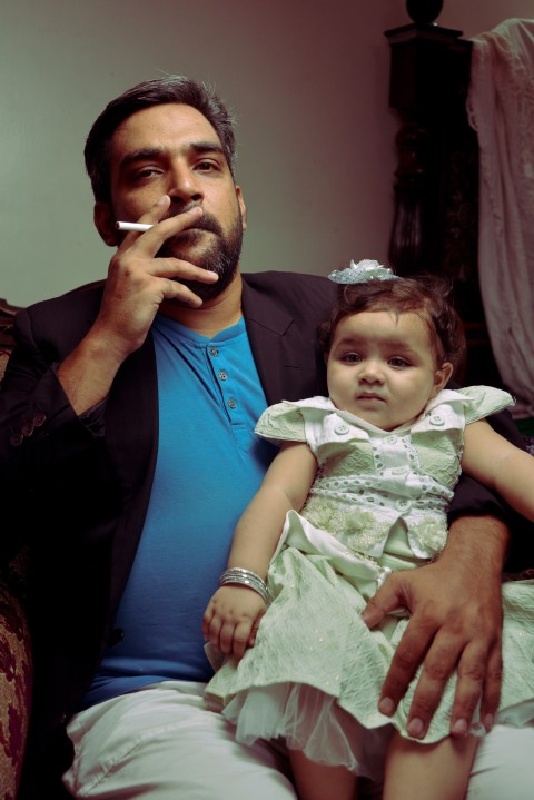 Baby photography dad posing for camera as 2nd hand smoker
