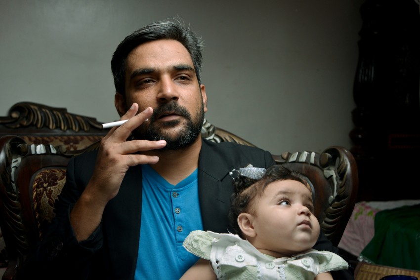 Baby photography   with dad posing for camera as a smoker acting as a 2nd hand smoker