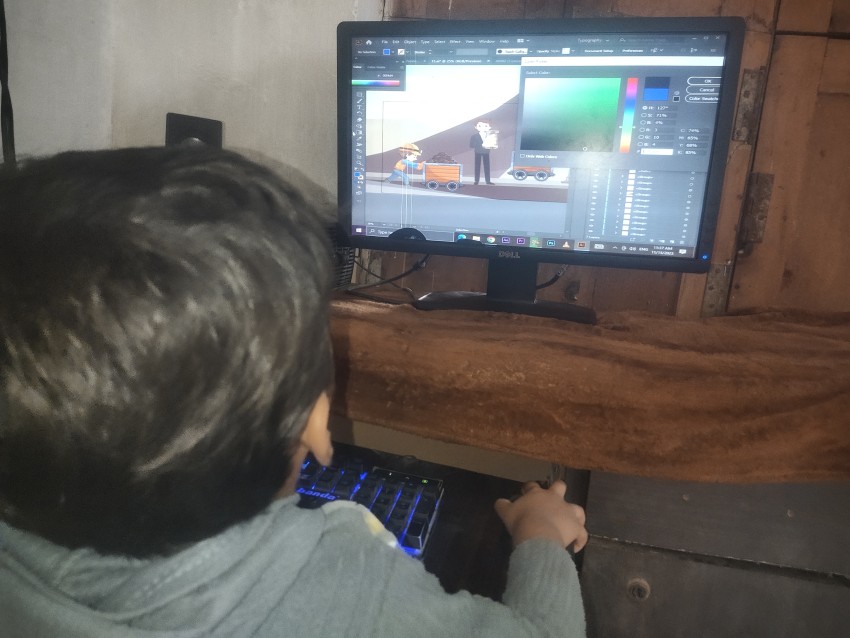 Back view of little boy designing on computer