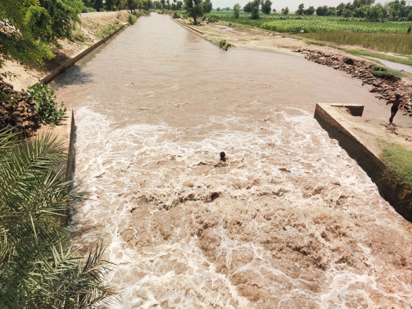 Children are enjoying bathing in the fast flow of canal water
