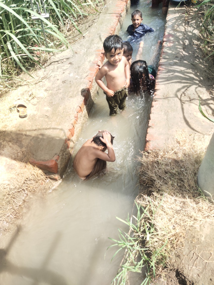 Children bathing in Tubewell water in a small cement canal