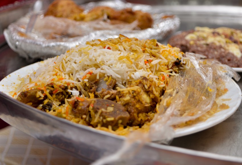 Colorful Bohra mutton biryani white plate with plastic wrap cover in a thali