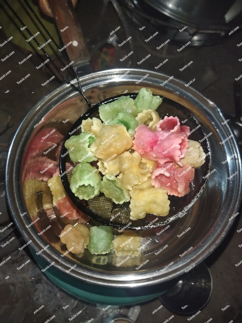 Colorful papads that are being taken out after frying in a pan at home