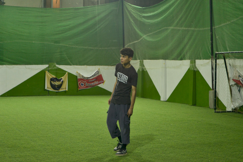 Futsal court player standing on a green floor ground night match