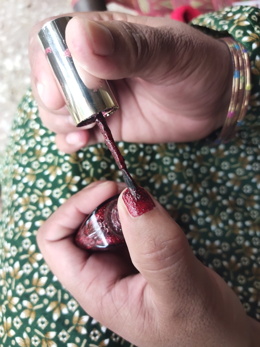 Girl applying nail polish on her nails