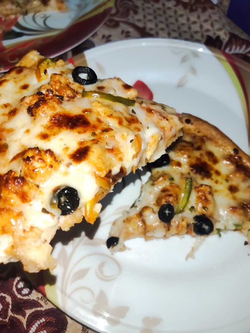 Pick up the creamy pizza for eating, delicious hot pizza on the plate