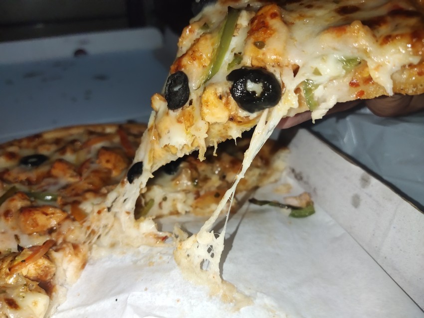 Pick up the full creamy pizza for eating, delicious hot pizza in the pizza box