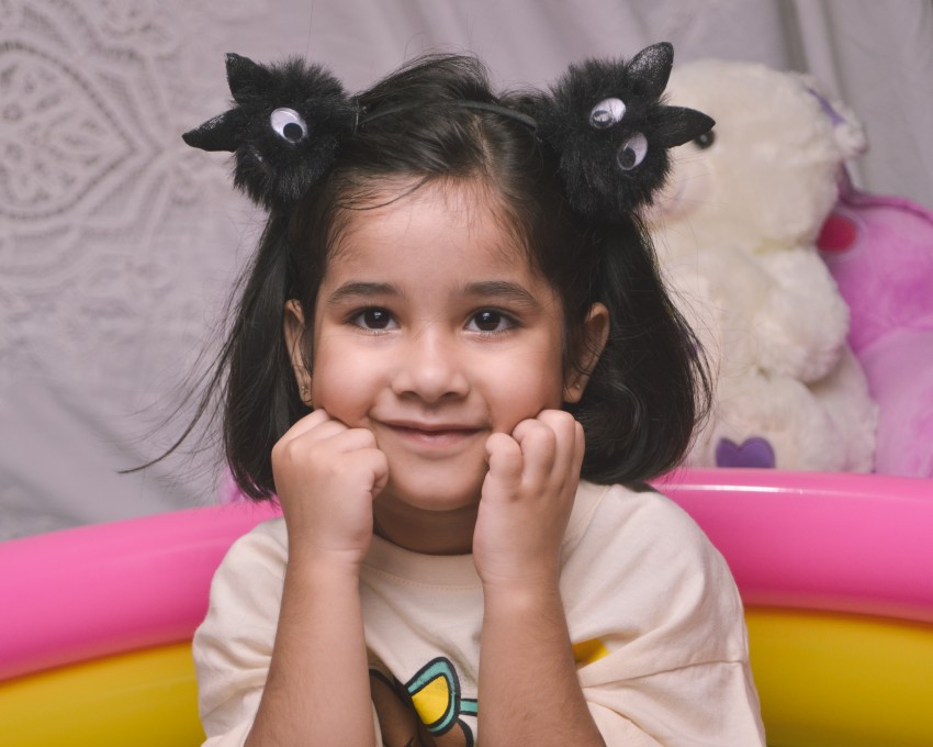 Preschooler with both hands on face posing for camera