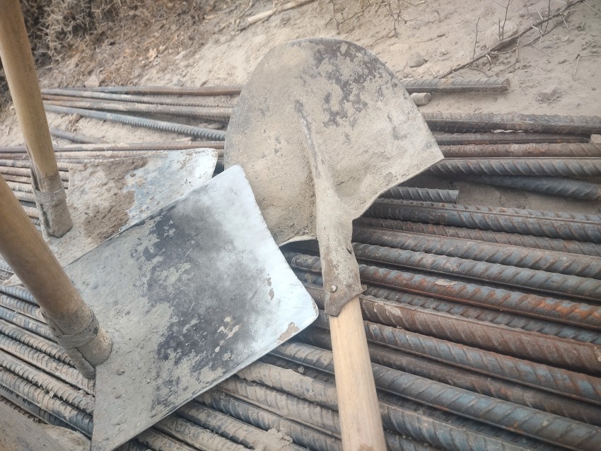 Shovels, placed on iron rods, help in the construction work.