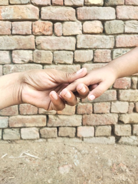 The father holds his son's hand and supports him.