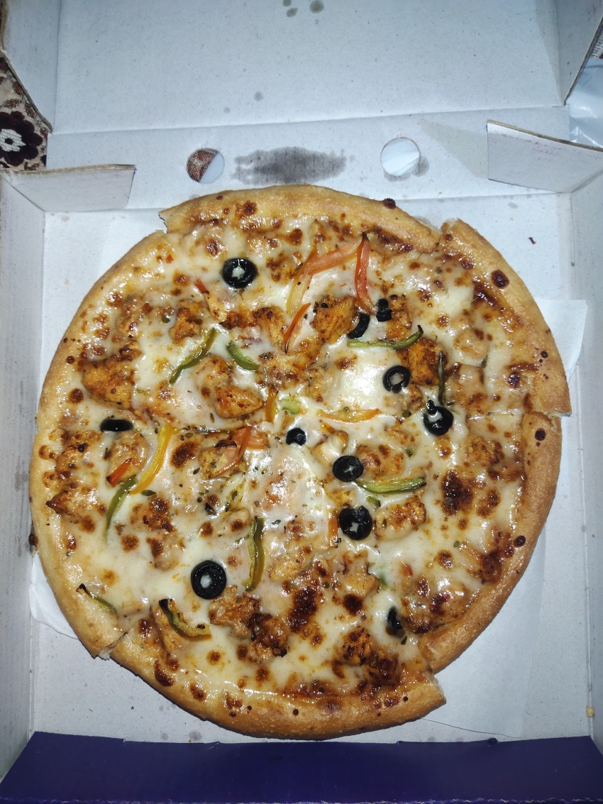 Top view of fully creamy, chili and hot pizza in the pizza box